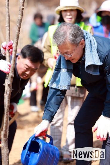 장인홍 구로구청장이 나무를 심고 물을 주고 있다.