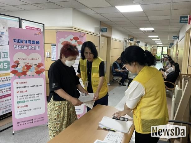 치매안심센터 직원이 의료시설에서 치매 사업을 안내하고 있다