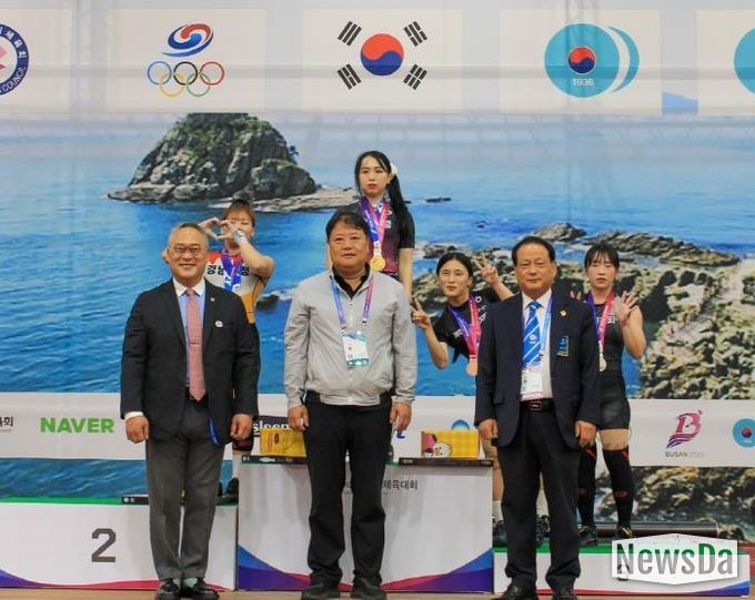 수상대에서 금메달을 걸고 선수들과 기념사진 찍는 신재경 선수(수상대 왼쪽 2번째)