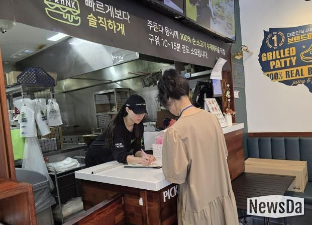 성남시 어린이 기호식품 전담관리원이 지난 9월 학교 주변 햄버거 판매점에서 영업자와 종업원의 건강진단 실시 여부를 점검하고 있다