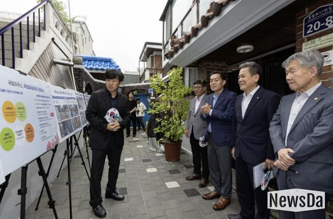 수원시와 한국보훈복지의료공단이 수원지역 독립유공자 후손의 집수리를 지원한 새빛하우스 앞에서 관계자들이 사업 설명을 듣고 있다.