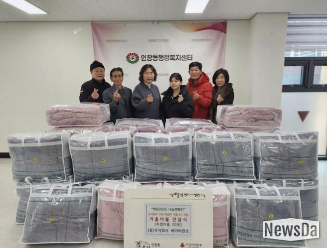 권소미 대표와 김경애 동장이 인창동 행정복지센터에서 이불 전달식을 진행하고 있다