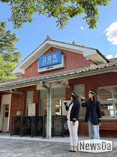 관광객들이 고모역에서 역무원 체험을 하고 있다.