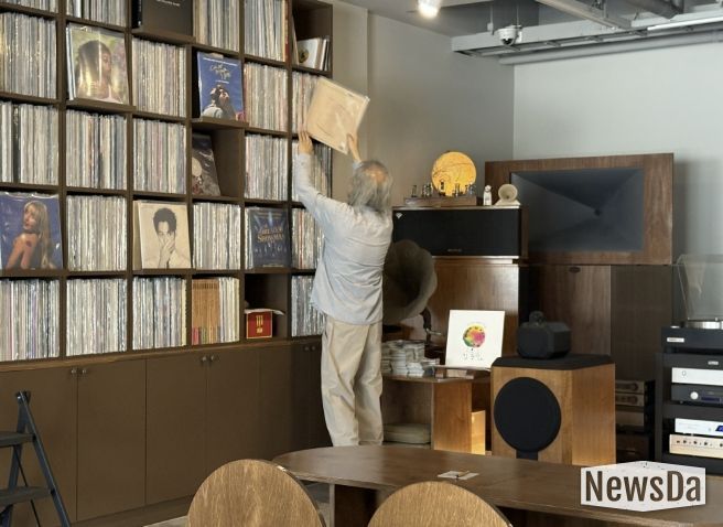 음악감상실 온 주인장이 신청곡 LP를 찾고 있다.