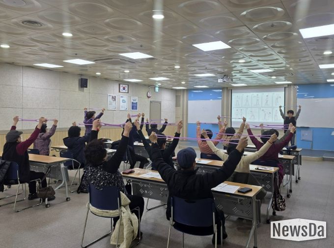 어르신들이 ‘튼튼 시니어 운동교실’에서 탄력밴드를 이용한 운동을 하고 있다.